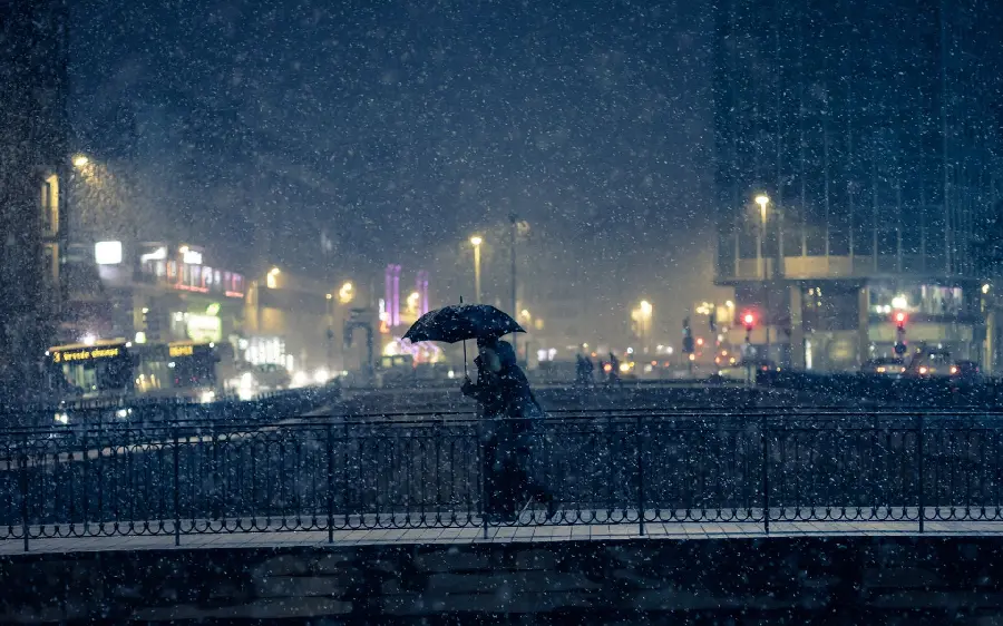 Download free photo of a girl with a snowman sitting on a bench with a city landscape wallpaper