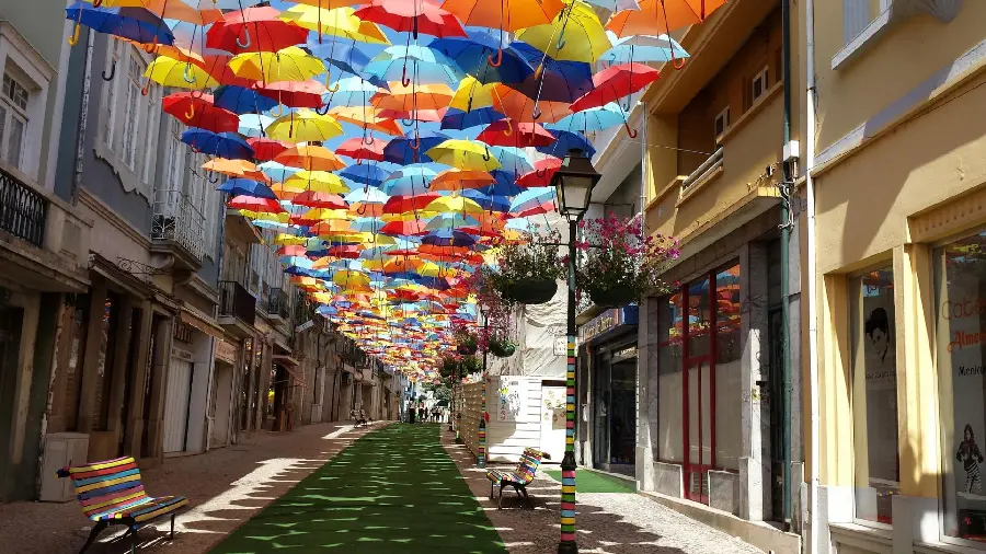 A picture of colored umbrellas in the sky of a dream city