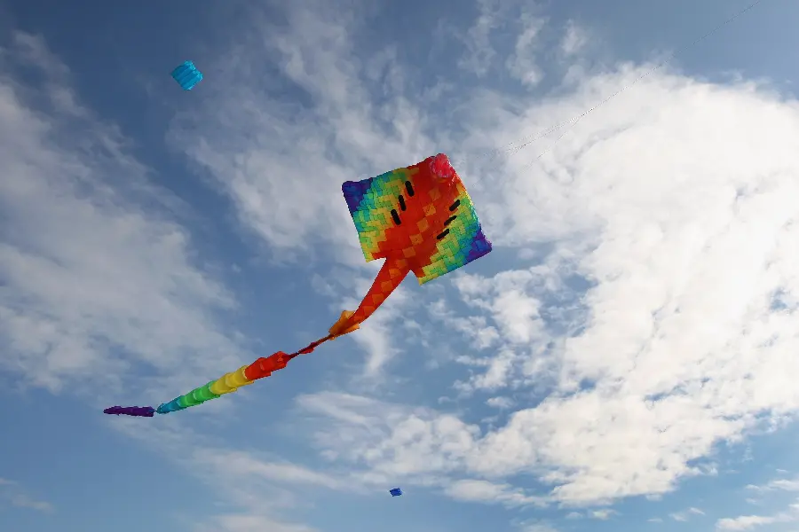 Simple and unedited background of a colorful kite flying in the sky 