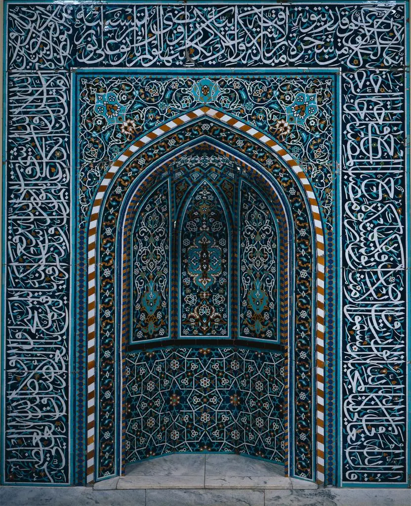 Image of the door of a religious place with Islamic design and Quranic texts
