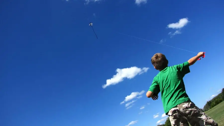 Simple and un-effects photo of a boy playing with a kite