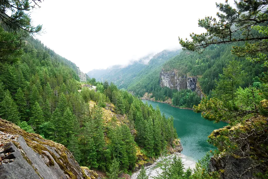Photo of a valley and rocky crevice with green and high mountains
