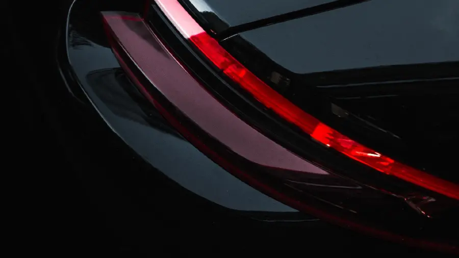 Stylish and special HD photo of a dark and red sports car headlight