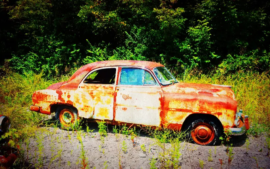 Wallpaper of an old abandoned car in the forest