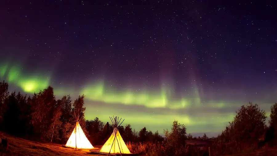 Wallpaper of a dreamy camping by the lake when the auroras appear in the sky