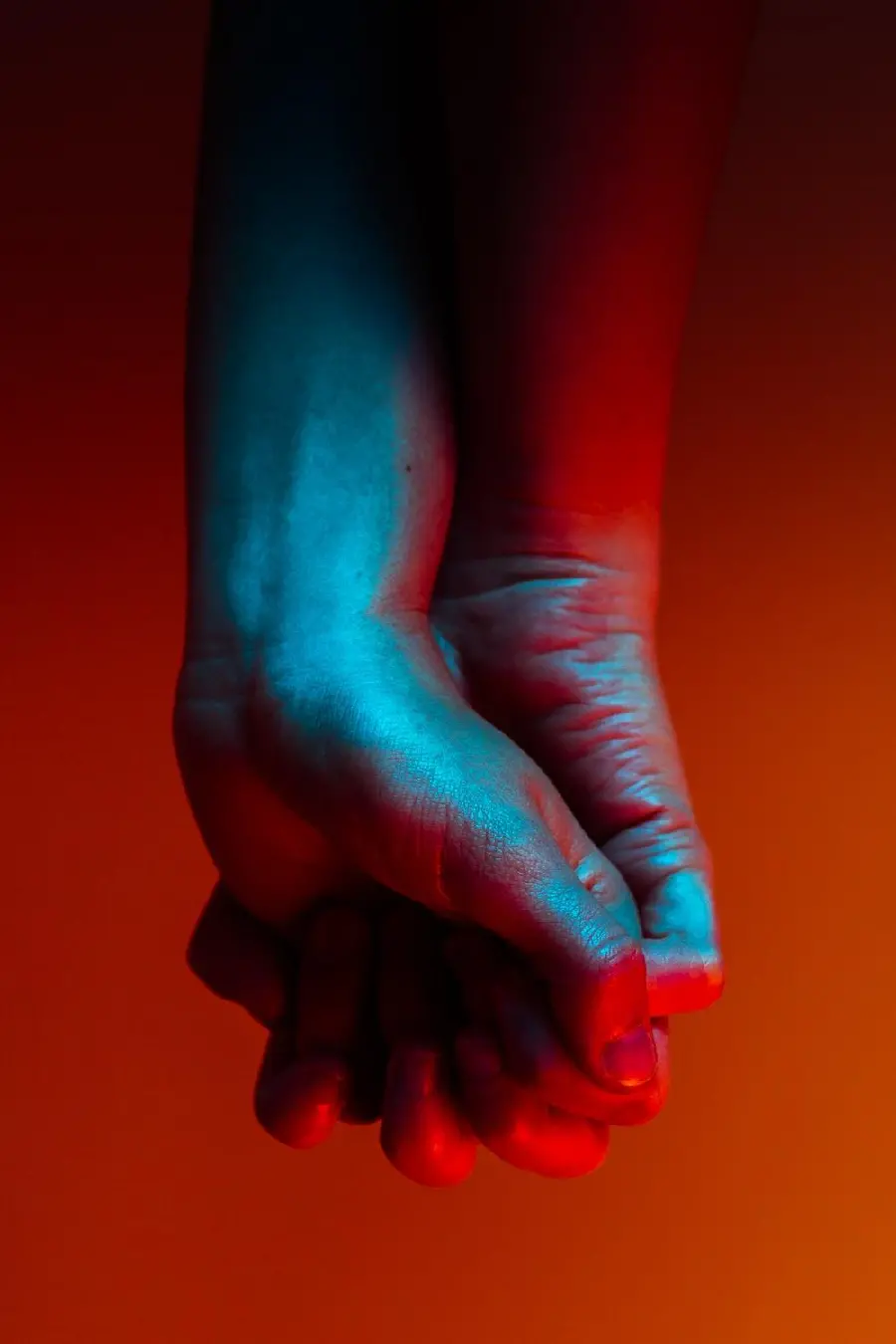 Free and high-quality photo of hands in hand with a red background 