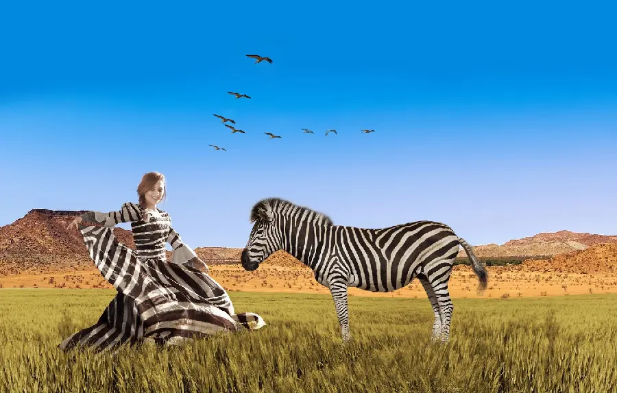 Wallpaper of a young girl in a zebra dress next to a zebra in the savannah