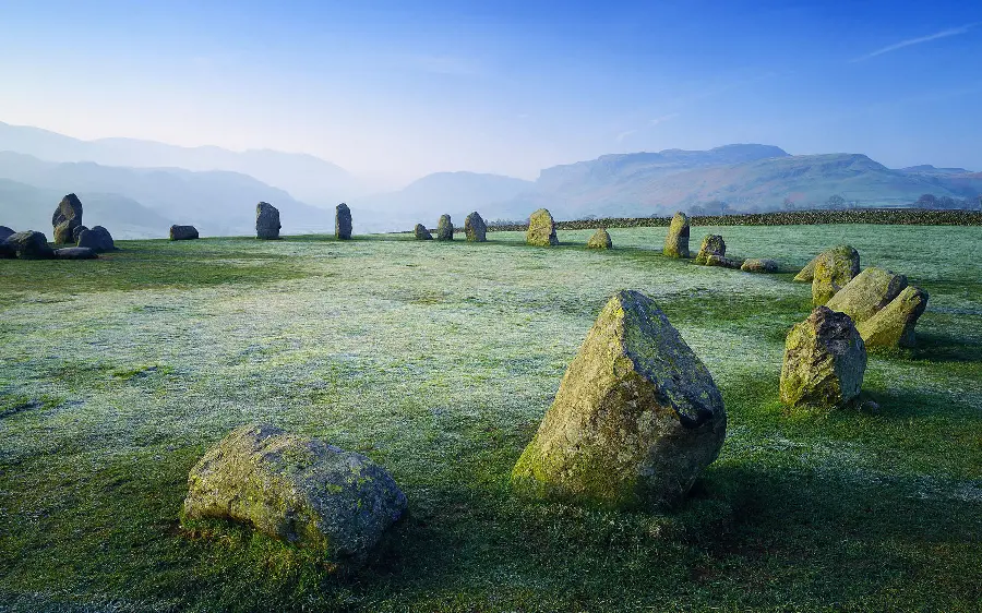 Beautiful wallpaper of a grassy field with strange pieces of rock