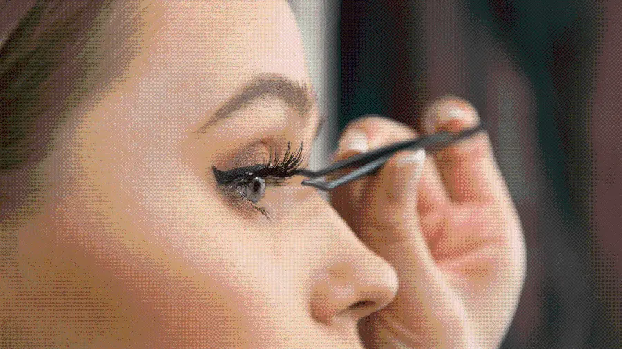 Download photo of young woman choosing false eyelashes 