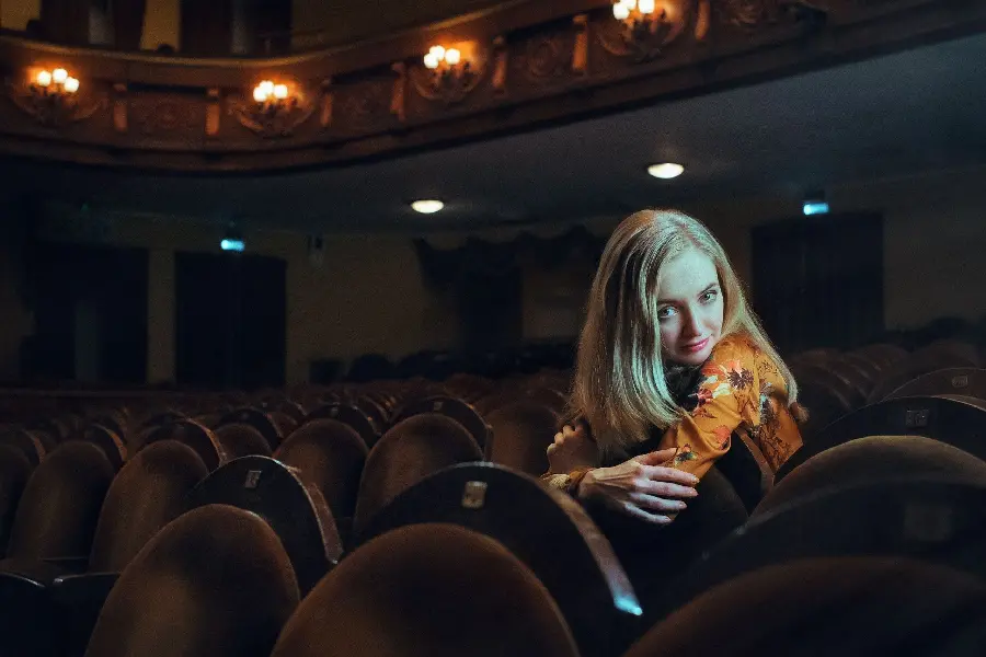 Spectacular and artistic photo of a girl in a theater hall for your phone