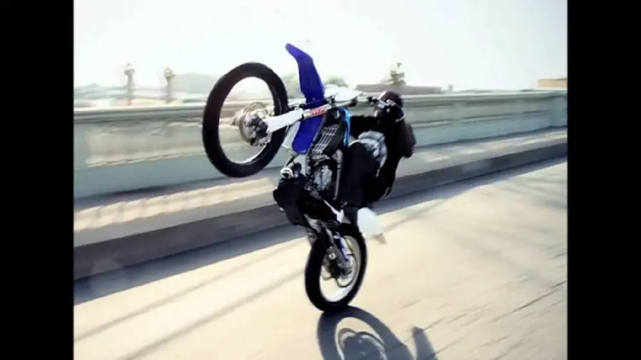 Wallpaper of one-wheeling and turning rough and tough on the street with motocross