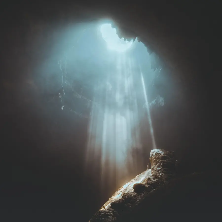 Wallpaper of light shining from the surface of the earth in a dark cave amazing 