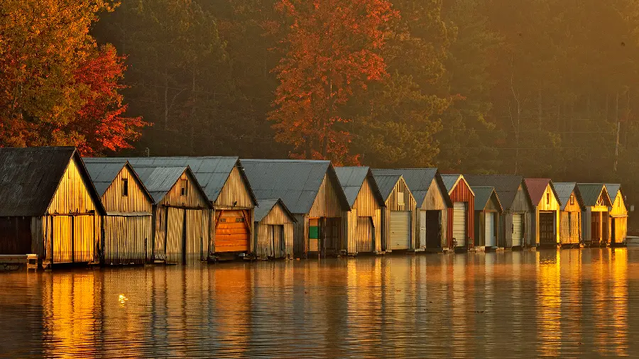 A very beautiful picture of cottages by the lake with an autumn view at sunset
