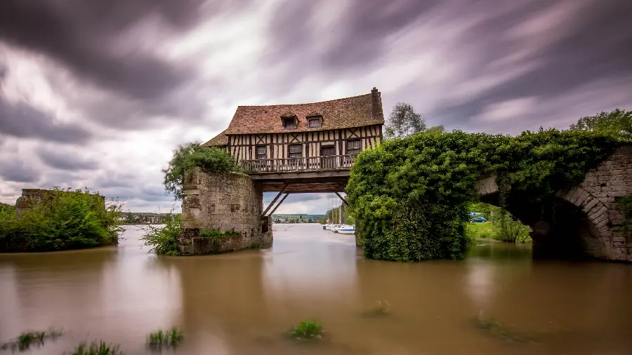 Dreamy and incredible image of a romantic wooden hut on a strong green bridge