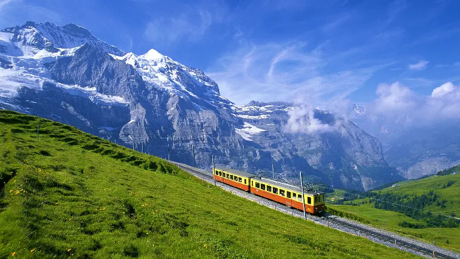 Download a photo of a train moving on rails in steep foothill areas 