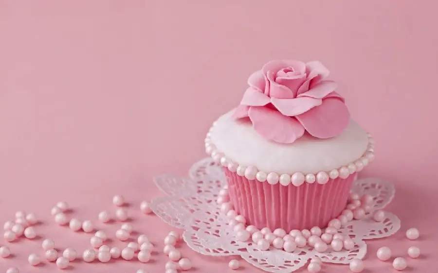 Photo of pink and white homemade cakes and sweets with a simple background 