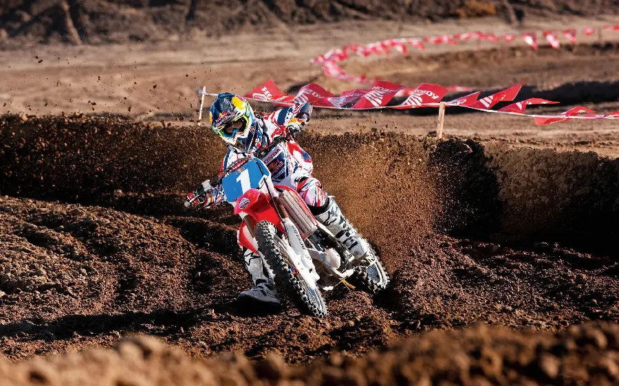 Wallpaper of a professional motocross rider getting stuck in the mud in a speed race 4k