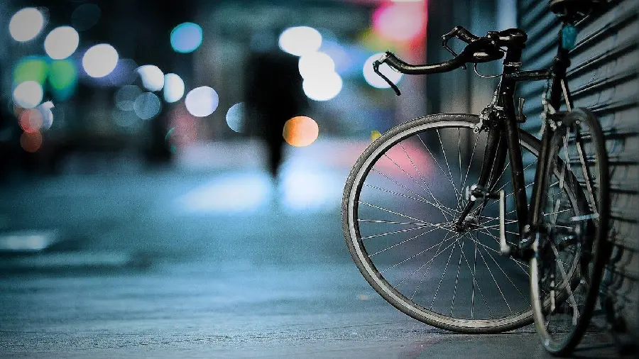Wallpaper of an abandoned bicycle on the street with a lone passerby