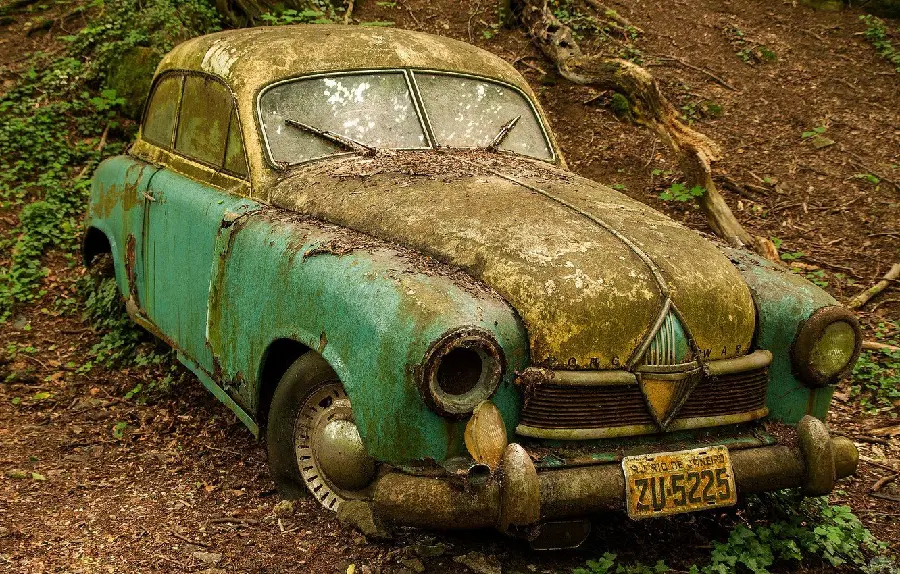 Stock of an old car surrounded by weeds