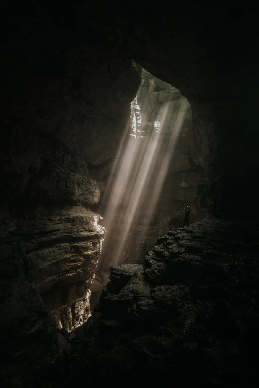 Dark underground cave background photo with light holes from Earth's surface 