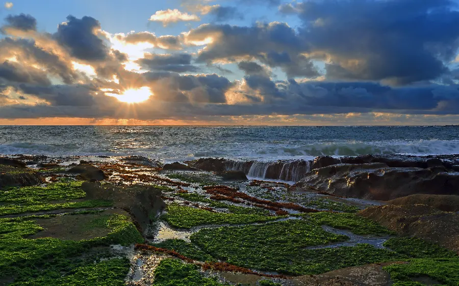 Download a photo of a seascape with a dreamy and cloudy sky and sunlight