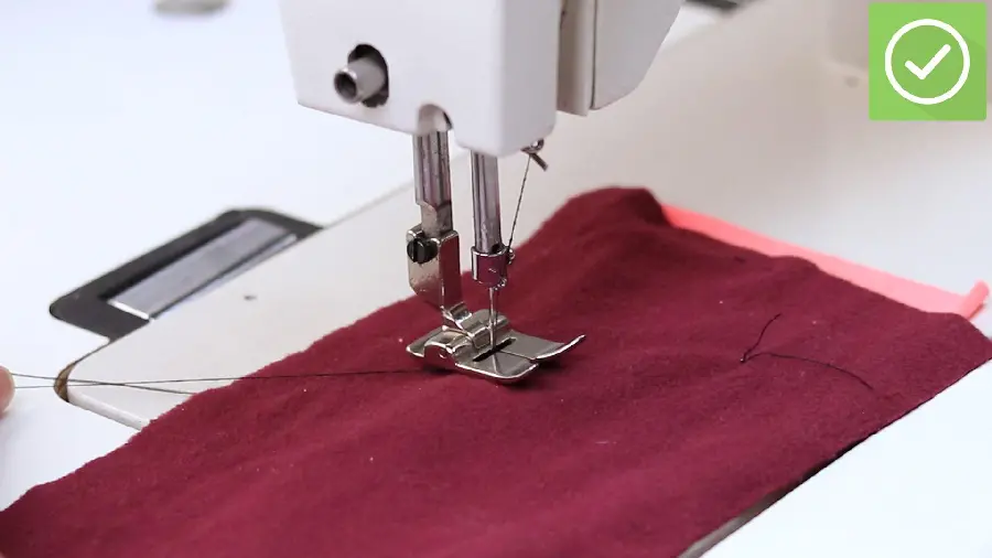 Background of a sewing machine sewing crimson fabric in excellent quality