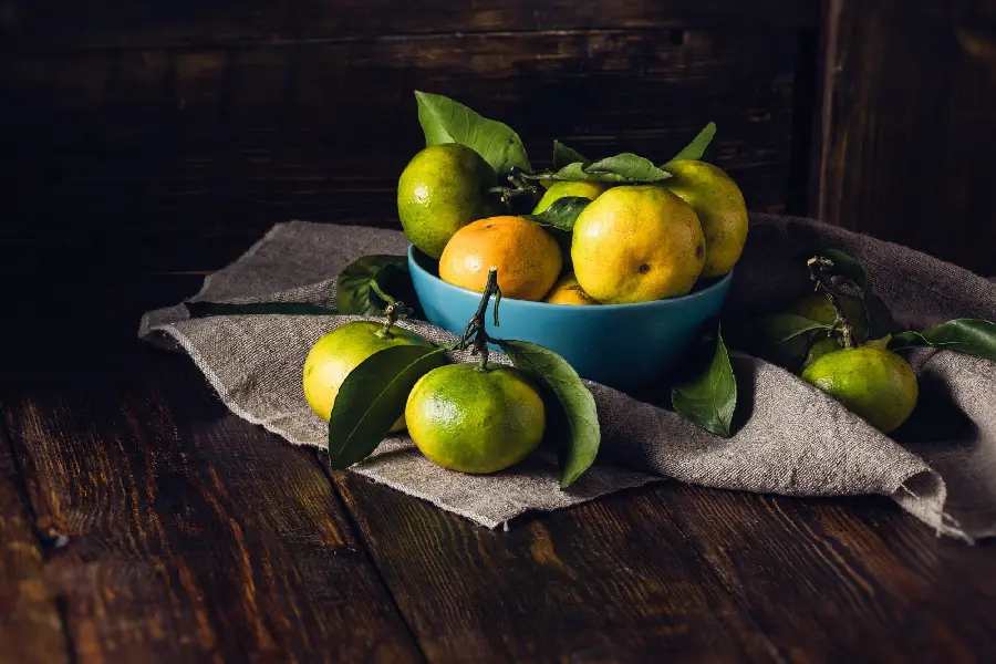 HD background of sweet and juicy unripe tangerines on the table