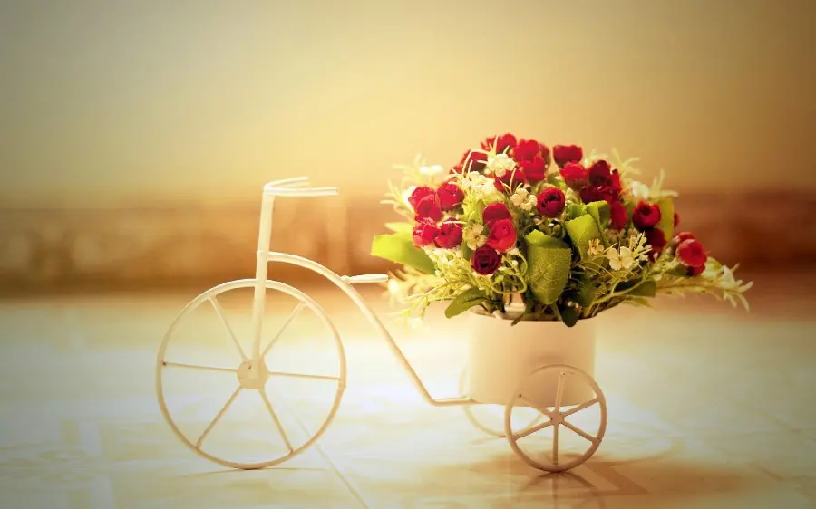Decorative photo of a bicycle-style vase stand with a bouquet of miniature roses