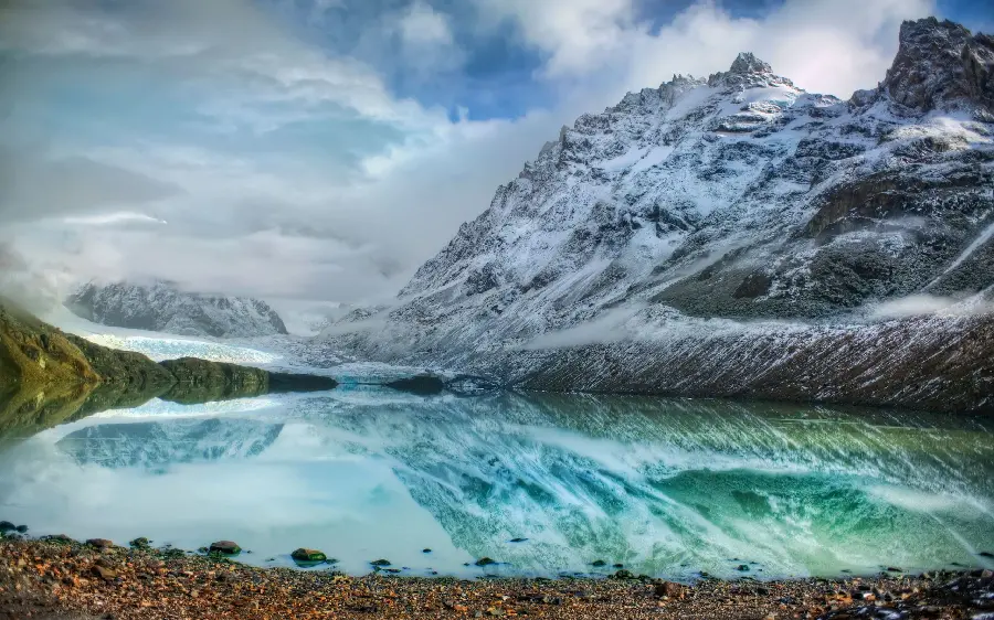 Incredible image of a high mountain lake full of water, icy and snowy