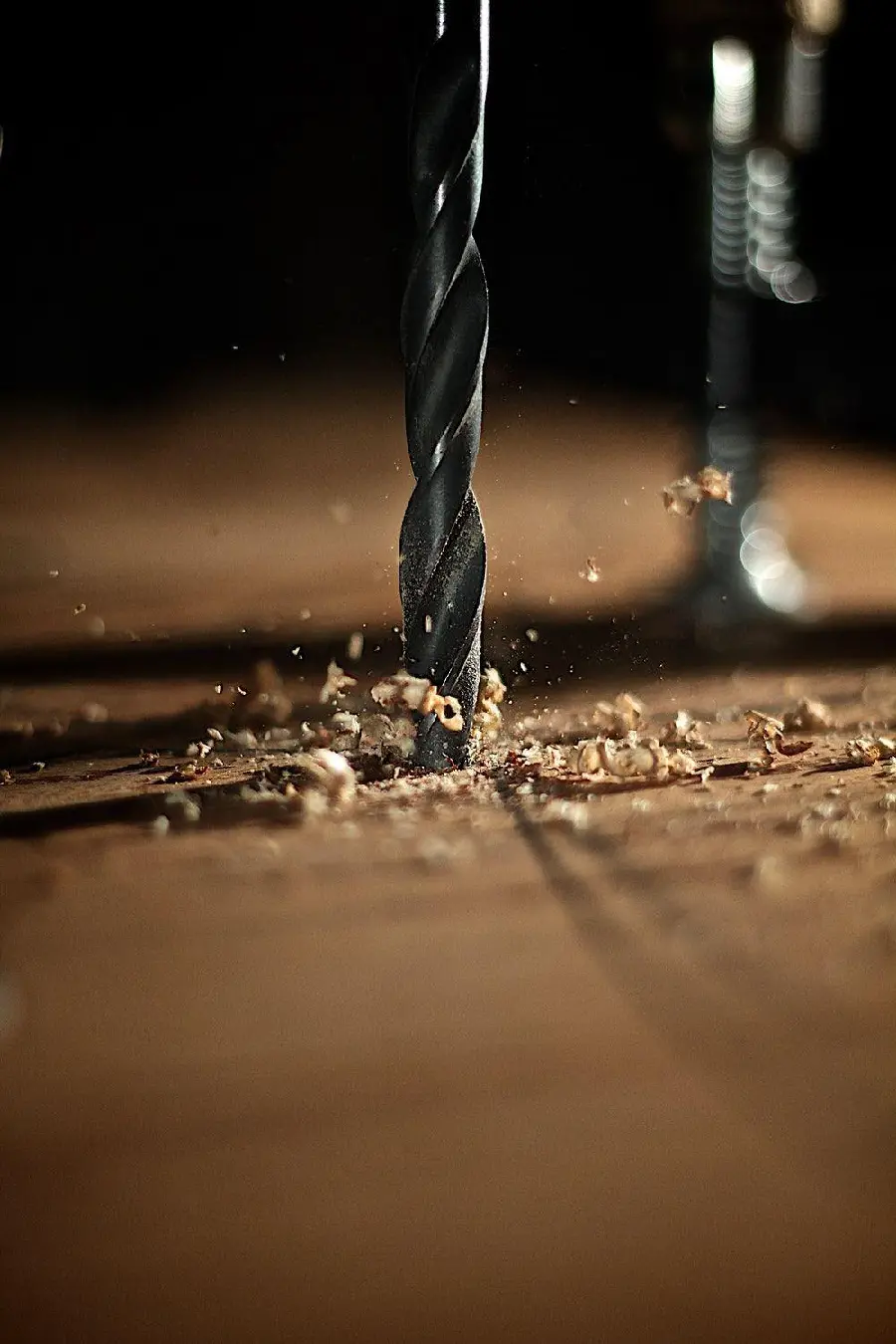Photo of a drill and a drill bit when drilling wood with a carpentry theme
