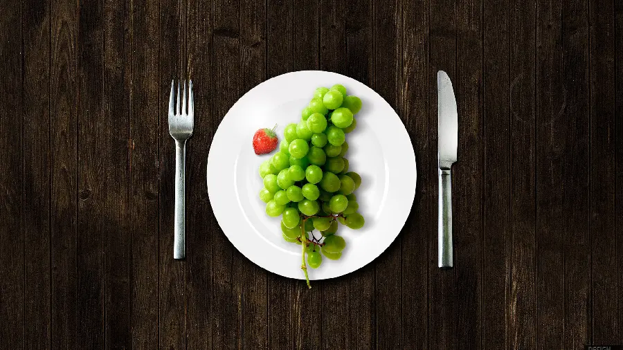 Wallpaper with an interesting and different design of green grapes designed on a plate