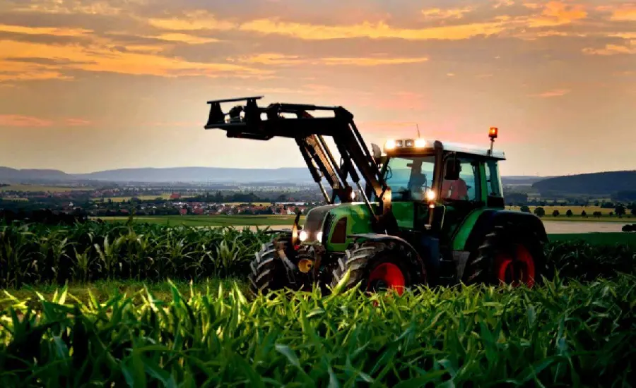 Laptop-sized wallpaper with a tractor at sunset