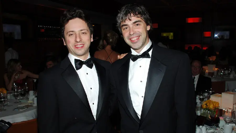 Photo of Larry Page and Sergey Brin in matching white suits and dresses