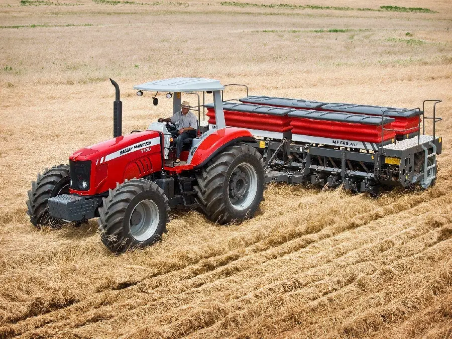 Background with a farmer working with a tractor and a combine on a large farm