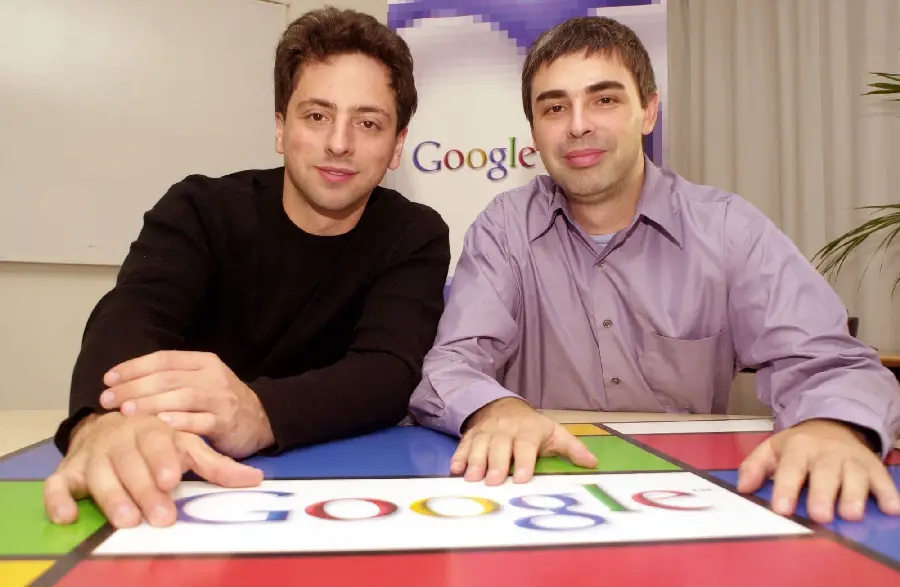 Photo of Larry Page and Sergey Brin with a Google background