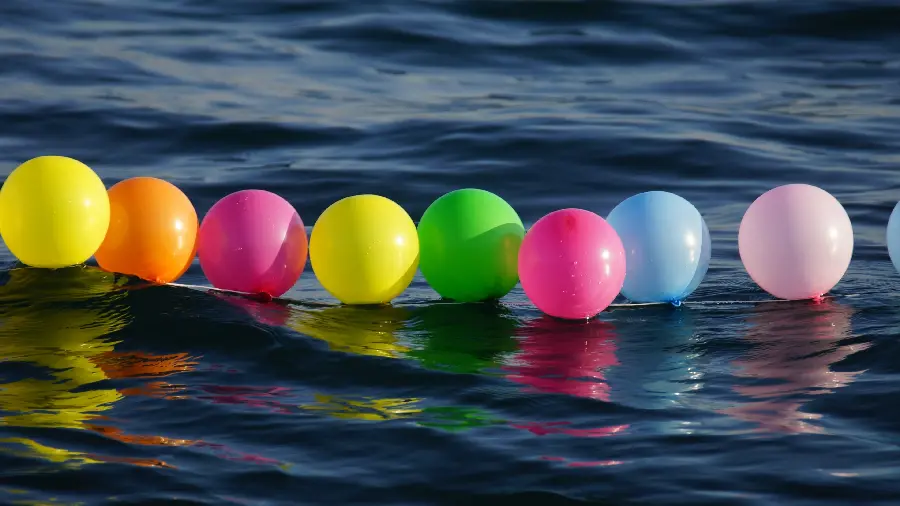 New creative and artistic image Colorful balloons floating on the water