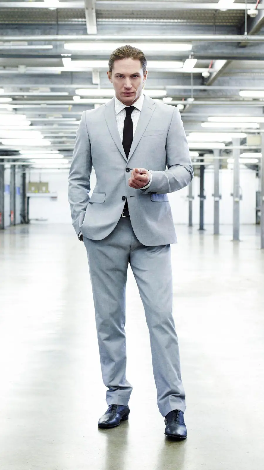 Photo of Tom Hardy in a formal gray suit 