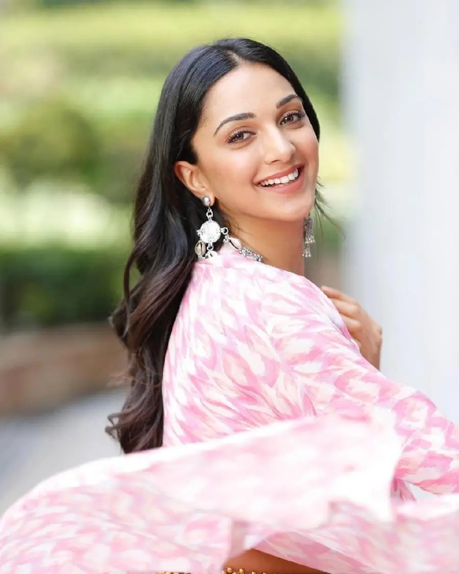 Kiara Background Photo Advani in a pink dress with a sausage 