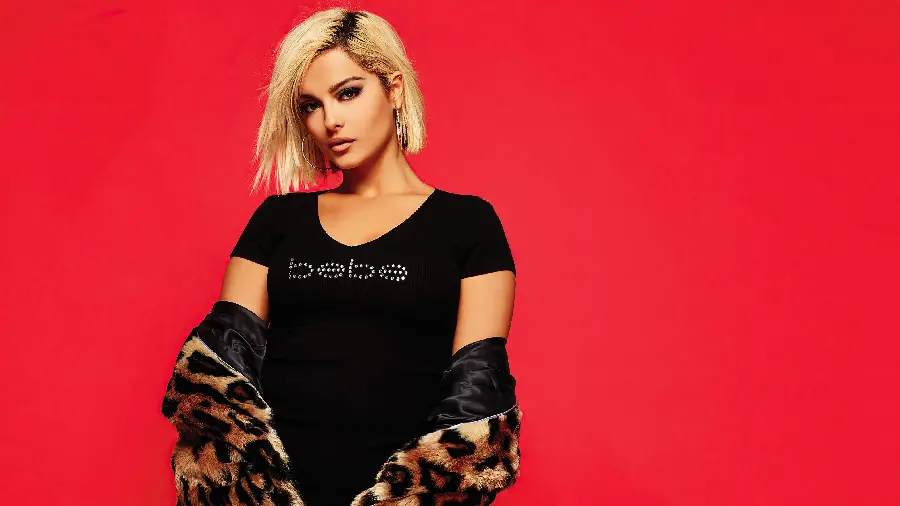 Bebe Rexha with a black dress and a red background