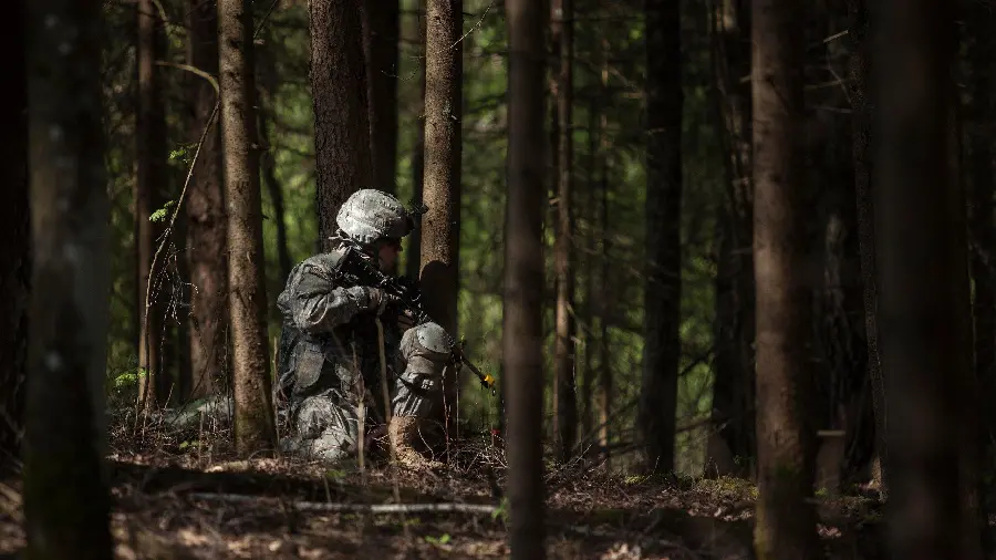 Download Wallpaper of a Military Soldier Camouflaged in the Forest