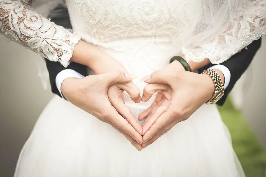 Heart gesture of the bride and groom's hands for photography in the studio