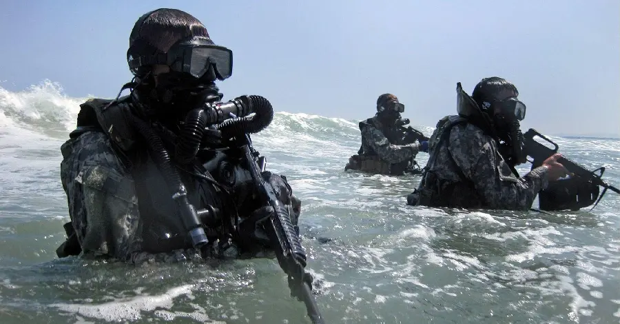 Photo of armed military divers in the sea and diving suits
