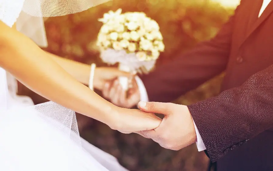 Photo of wedding hands of bride and groom holding hands