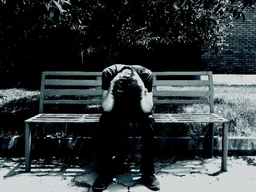 Lonely and Sad Boy Kneeling in the Park Sitting on a Bench Photo for Free Download