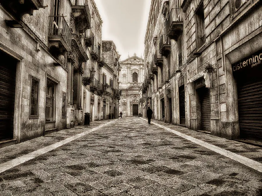 Black and white image of an empty cobblestone street in Italy
