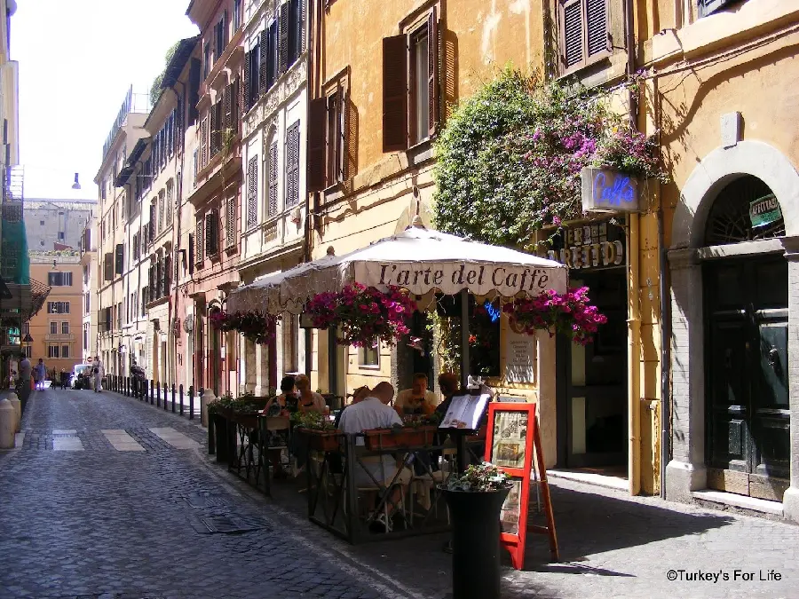 Image of tables and chairs of cafes along the Italian street