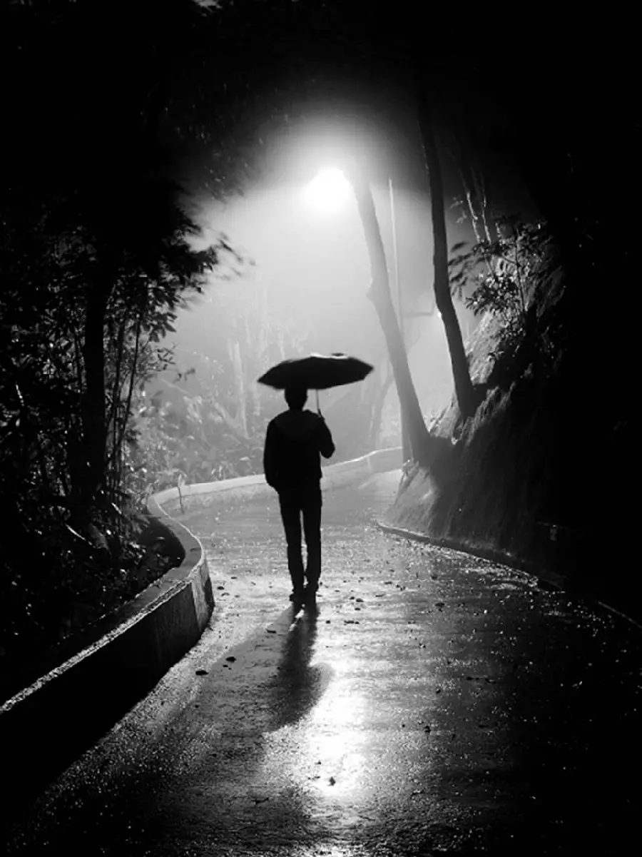 Photo of a lonely boy with an umbrella on a rainy day for a sad profile picture