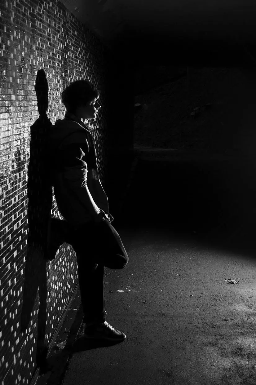 Free download of a sad and lonely boy leaning on the wall