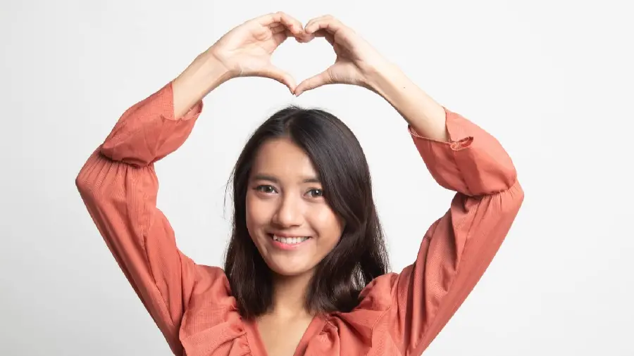 Photo of a woman showing a heart for International Women's Day on March 8