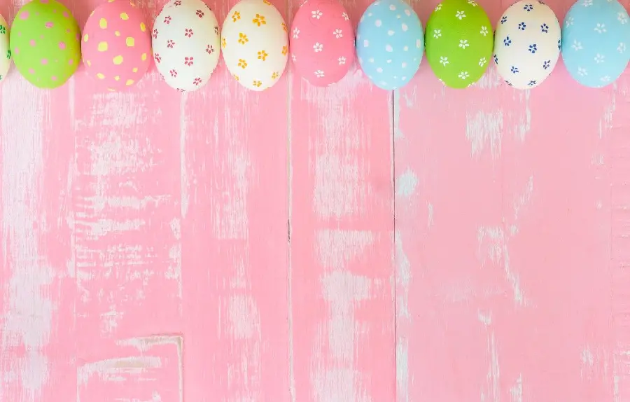 Wooden background with colorful painted eggs for writing text